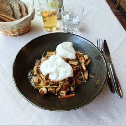 Geräucherter Tofu und gebratenes Gemüse auf einer würzigen Mandelsauce, garniert mit Reischips